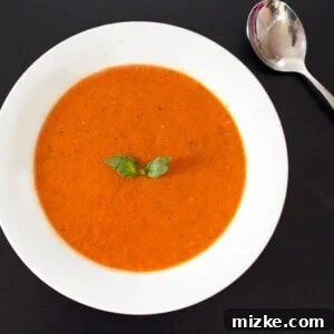 Close-up of a serving of Kickin' Tomato Soup, garnished with fresh basil.