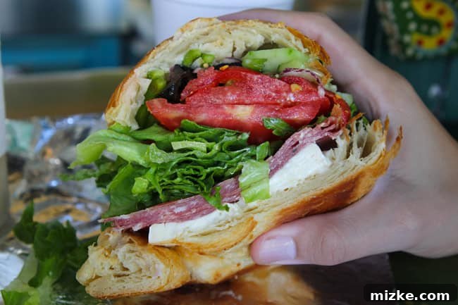 Neon Shores 12 Gourmet Saucisson Sec sandwich on a croissant from La Sandwicherie