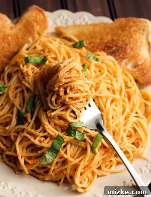Smoky Red Pepper Pesto Pasta with Tangy Goat Cheese 4 Fresh ingredients for roasted red pepper pesto pasta laid out, including spaghetti, red pepper pesto, goat cheese, and basil.