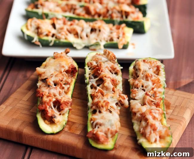 Stuffed Zucchini 2 Two vibrant green zucchini halves, scooped out and ready to be filled, sitting on a baking sheet.