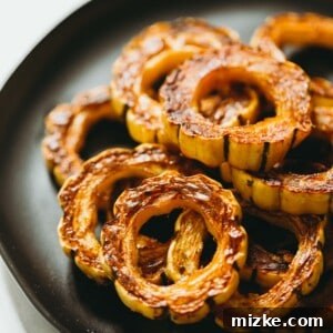 Caramelized Delicata Squash 5 Deliciously roasted delicata squash slices, golden and caramelized, ready to be enjoyed.