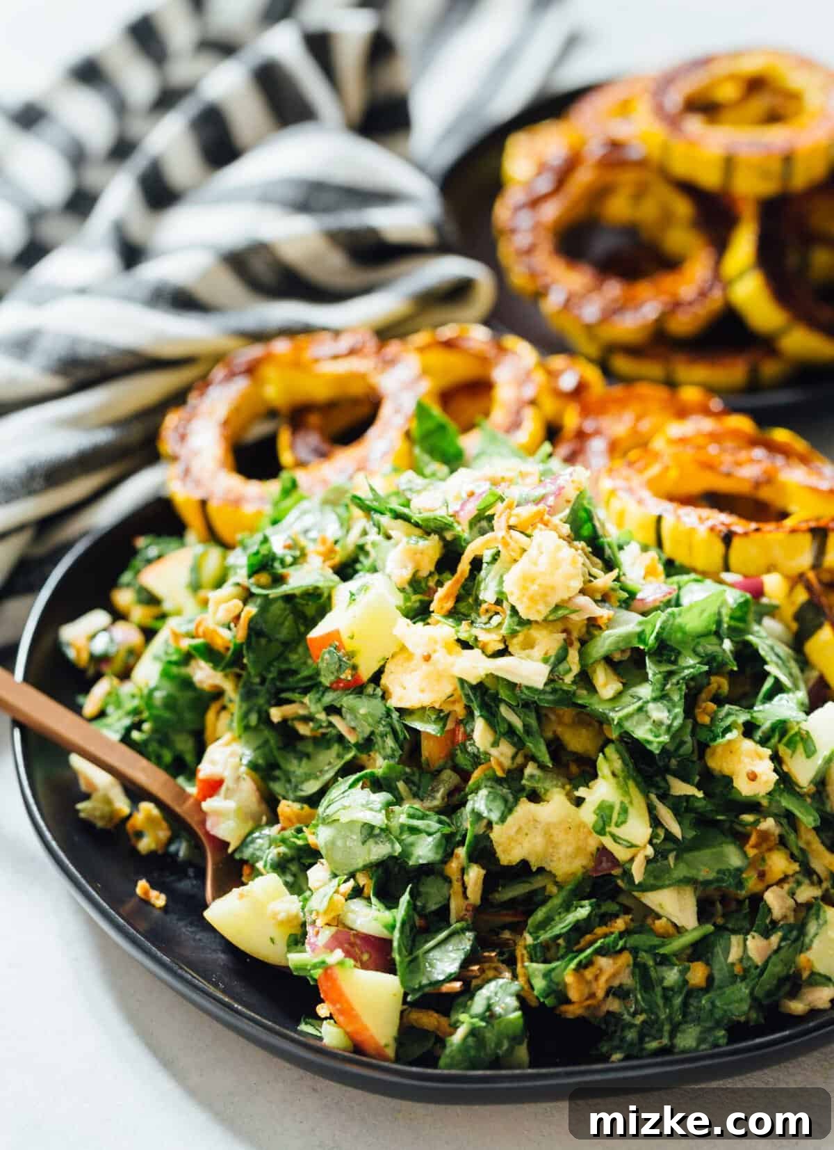A spinach tuna salad topped with roasted delicata squash is a heavenly combination! The delicata squash gives it a unique yet distinct sweetness but it also adds volume to make this salad hearty and filling! A close-up shot of the fresh spinach and flaky tuna, beautifully complemented by the golden-brown roasted delicata squash, highlights the vibrant ingredients. This heavenly combination delivers a unique sweetness from the squash, adding both exquisite flavor and robust volume to make this salad incredibly hearty and deeply satisfying.