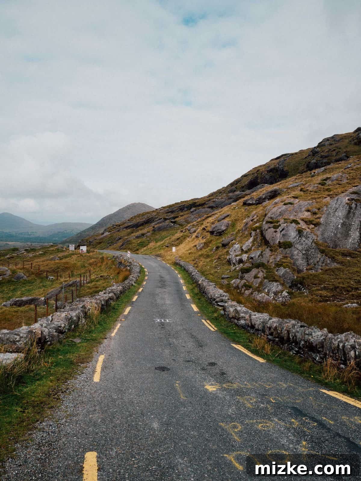 Ireland's Rugged Beara Peninsula 29 Stunning view of a vibrant green valley with a river or lake, seen from high up on Healy Pass during descent