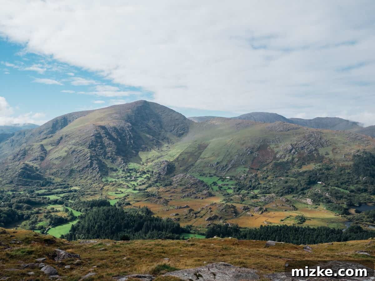 Ireland's Rugged Beara Peninsula 31 Wide shot of a beautiful Irish valley with a narrow road, bright green fields, and distant mountains