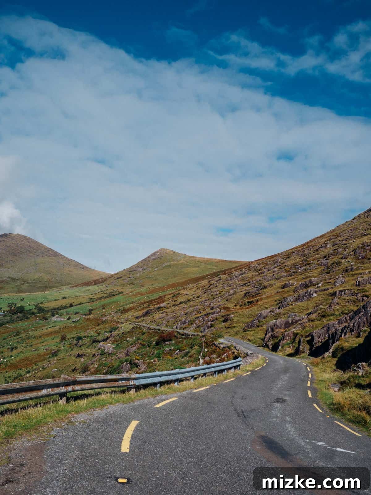 Ireland's Rugged Beara Peninsula 39 Final stunning panoramic view of a wide valley with dramatic mountains in the background, bathed in sunlight