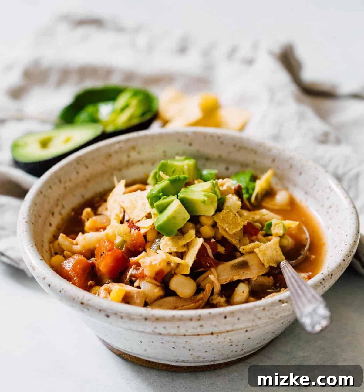 Stovetop Chicken Tortilla Soup ready to be enjoyed Close-up of a steaming bowl of chicken tortilla soup, showcasing the rich broth and colorful ingredients, garnished with cilantro.