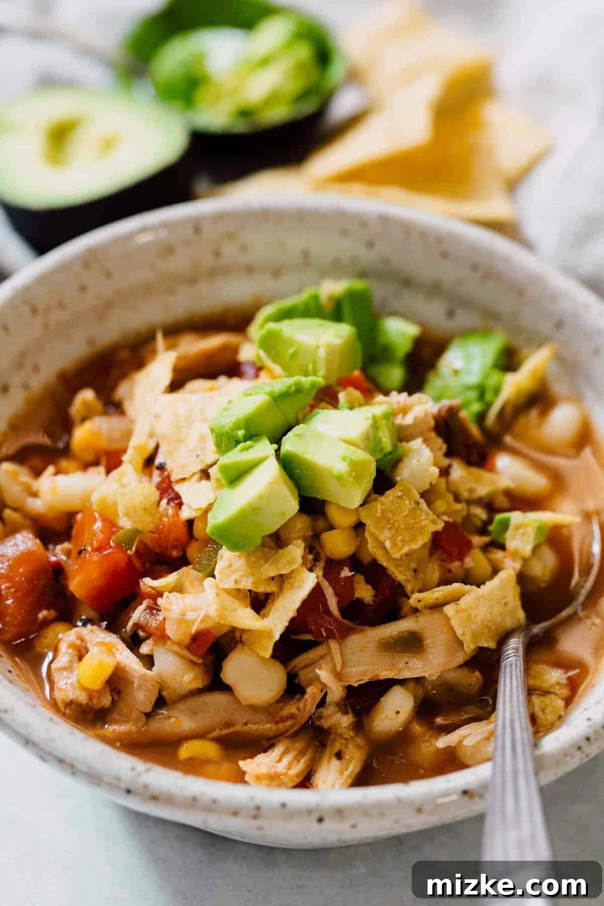 Fresh ingredients for Stovetop Chicken Tortilla Soup A vibrant array of fresh ingredients for stovetop chicken tortilla soup laid out on a kitchen counter, including chopped vegetables, spices, and chicken.