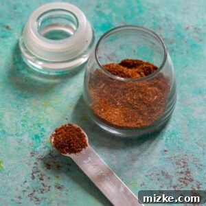 Homemade Fajita Seasoning in a jar with a measuring spoon