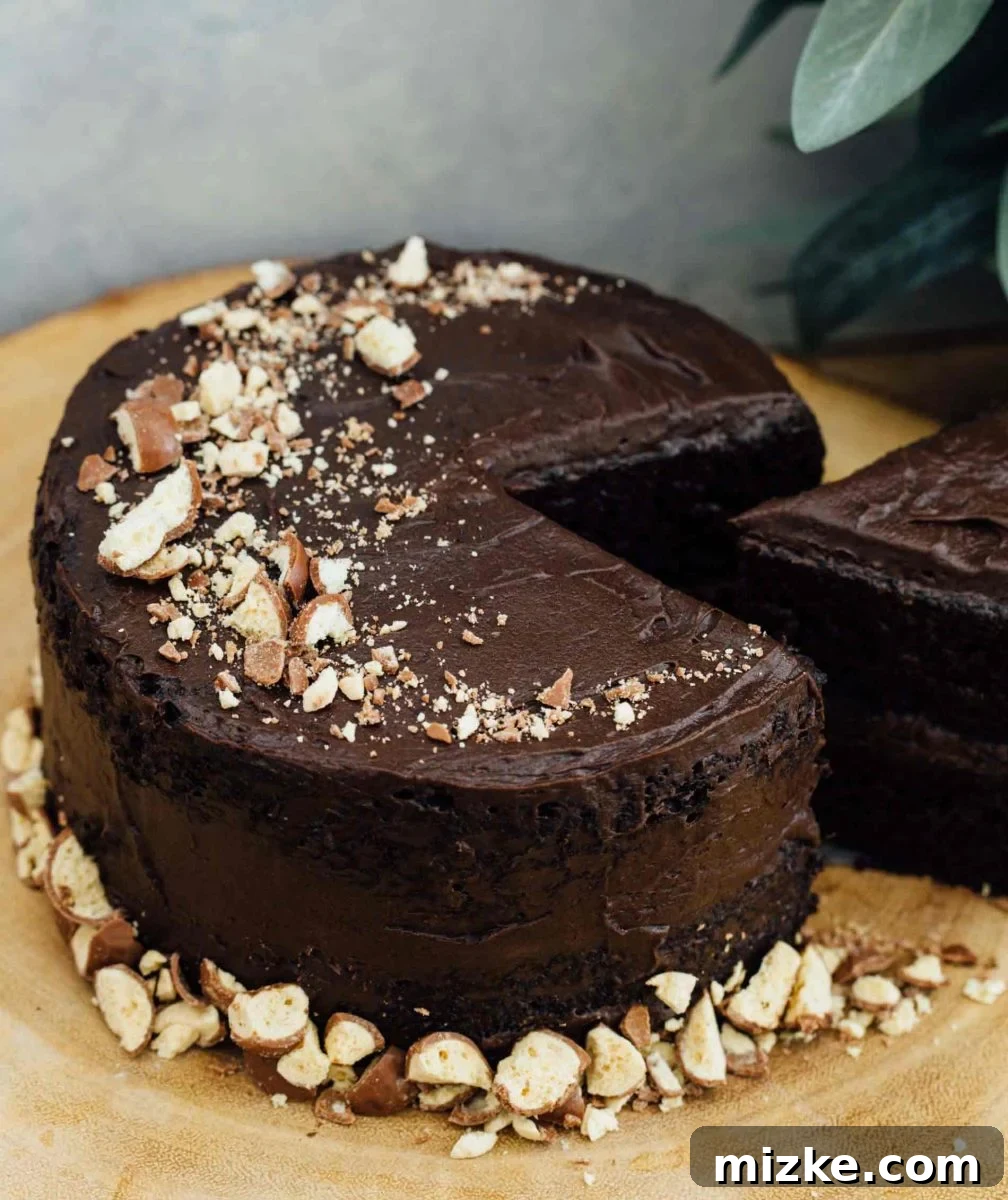 Indulgent Mini Chocolate Malt Cake: A Slice of Heaven This mini chocolate malt cake for two is perfect for any celebration or if you're just craving a chocolate cake and don't want to make a large one! Close up of cake slice showing moist texture.