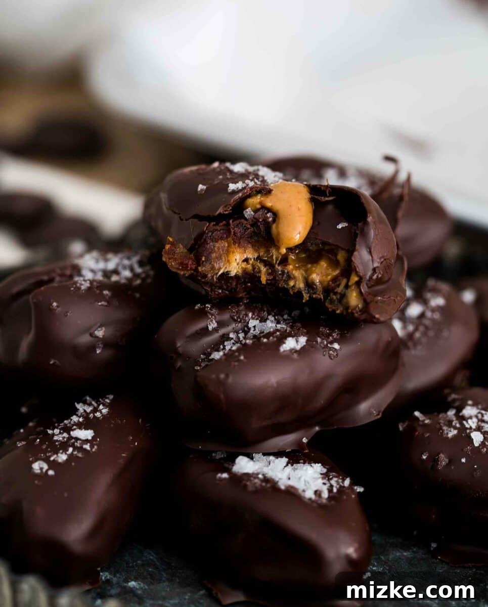 Homemade Chocolate Covered Stuffed Medjool Dates with Peanut Butter and Sea Salt Close-up of freshly made chocolate covered stuffed dates sprinkled with sea salt, ready to be enjoyed.