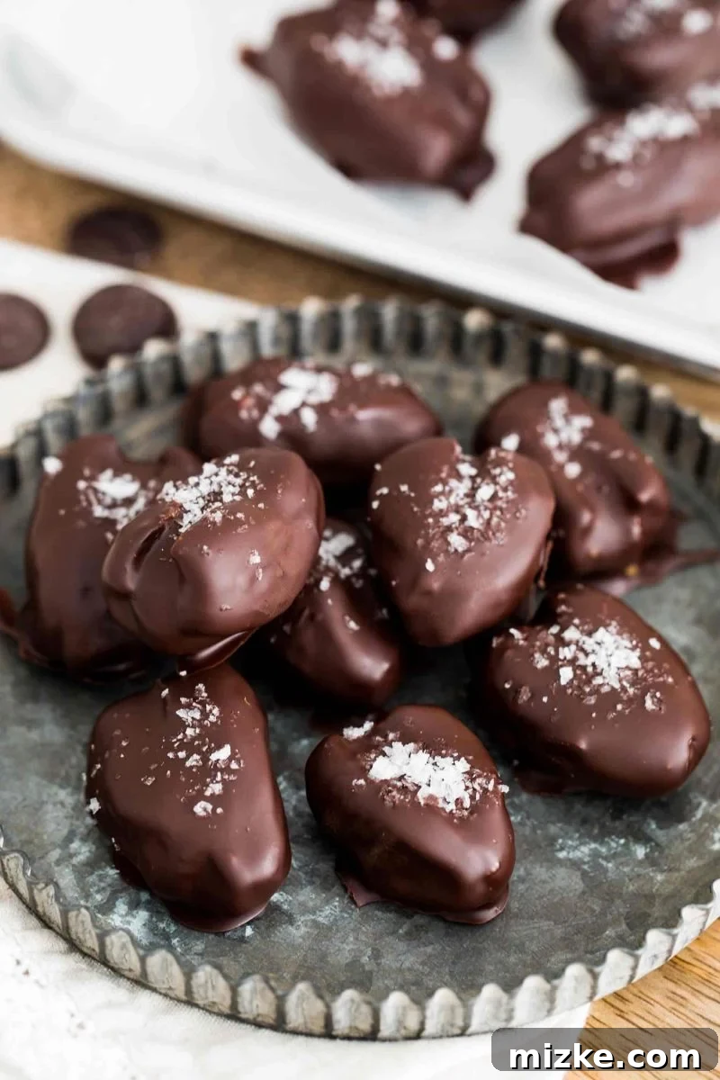 Easy Recipe for Stuffed Dates with Chocolate Coating and Nut Butter Filling A tray of chocolate covered stuffed dates chilling in the refrigerator, showcasing their glossy chocolate coating.
