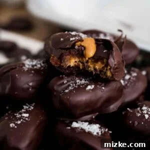 A beautifully arranged plate of chocolate covered stuffed dates with a sprinkle of sea salt.