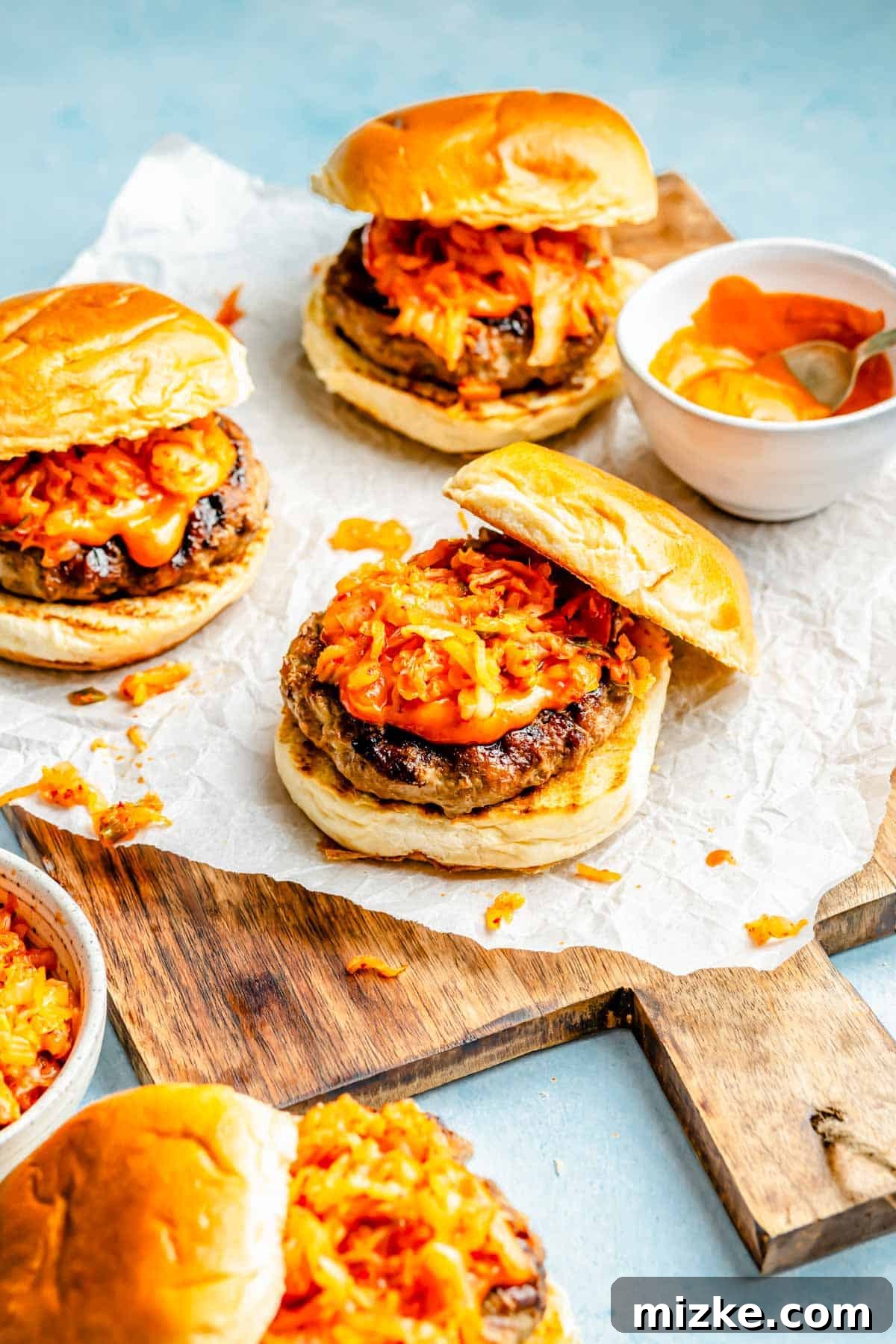 The Bulgogi Kimchi Burger 3 An open-faced Bulgogi Kimchi Burger on a wooden cutting board, ready to serve