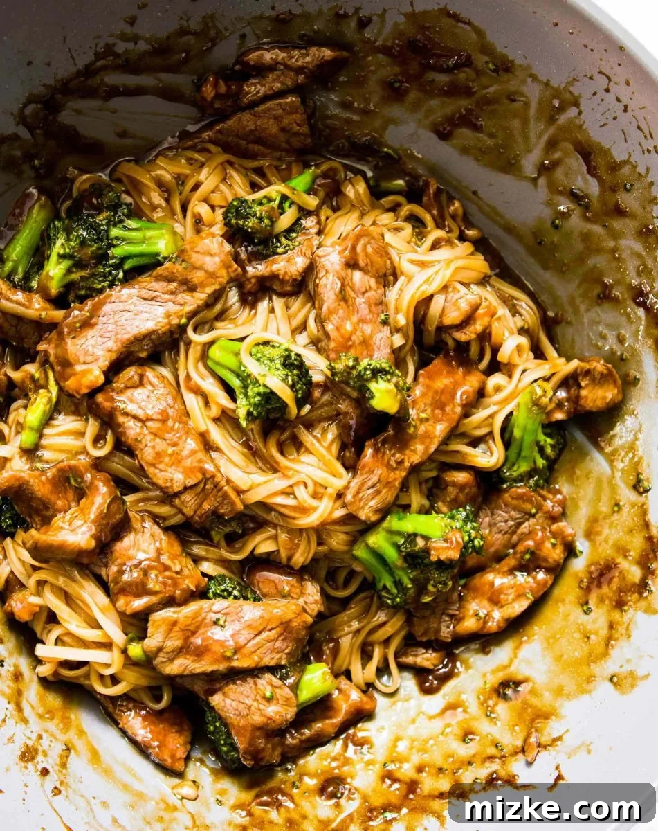 A vibrant bowl of Asian Beef and Broccoli Noodles, featuring tender beef slices, crisp broccoli florets, and slippery rice noodles coated in a rich, savory sauce. Perfect for a quick and satisfying weeknight dinner.