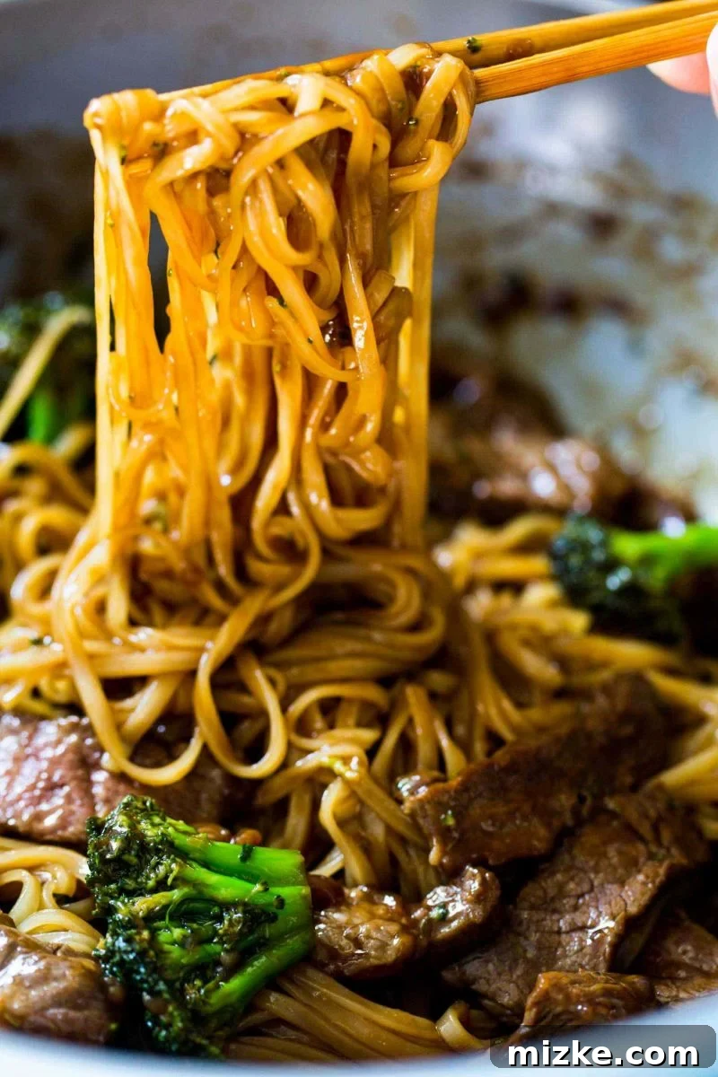 Thinly sliced boneless short ribs coated with arrowroot powder and Chinese rice wine, marinating in a bowl. This essential step ensures tender and flavorful beef in the noodle dish.