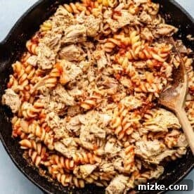 pasta and canned tuna fish added to the cast iron skillet with the tomato sauce.