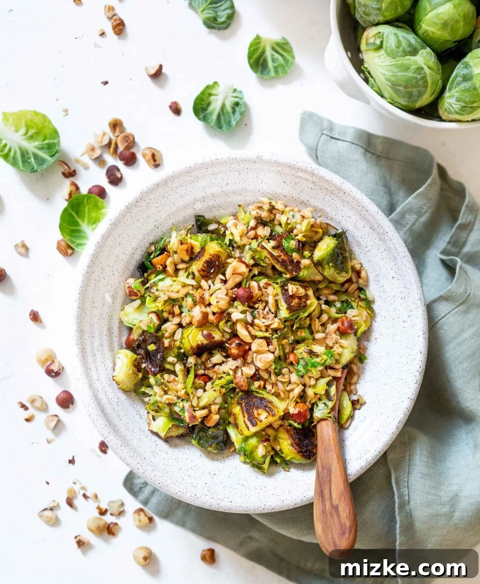 The finished warm roasted Brussels sprouts salad with farro in a rustic bowl, ready to be served. The textures and colors are inviting, promising a delicious and healthy meal.