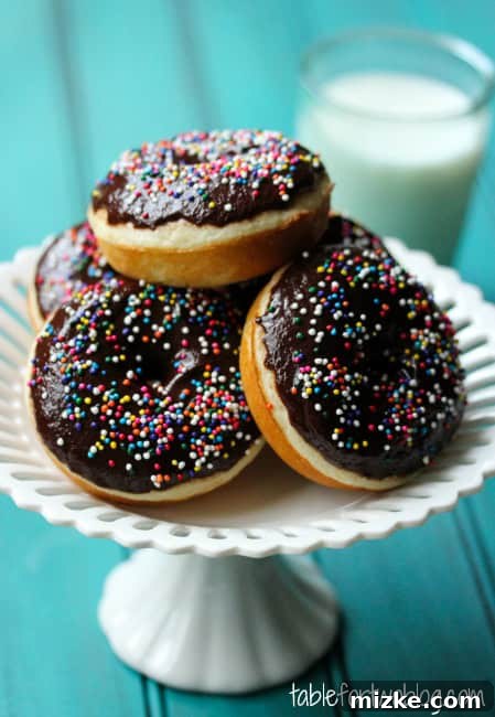 Irresistible Chocolate Sprinkle Donuts 2 Delicious baked chocolate glazed donuts with rainbow sprinkles on a cooling rack.