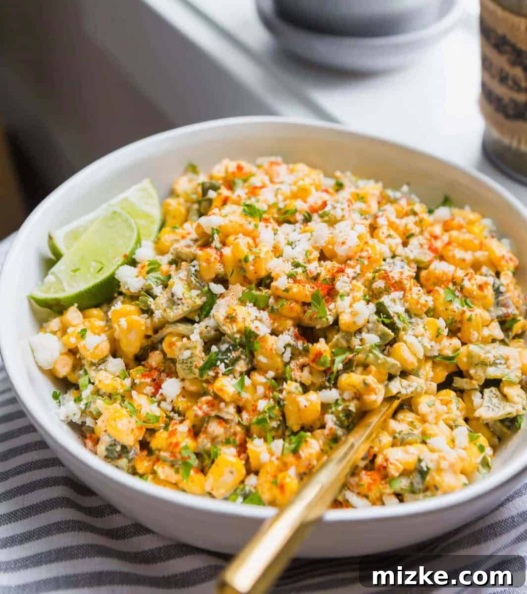 Poblano Elote Bowl 7 A large serving bowl filled with Poblano Mexican Street Corn off the cob, garnished with lime wedges and fresh parsley, ready for a gathering.