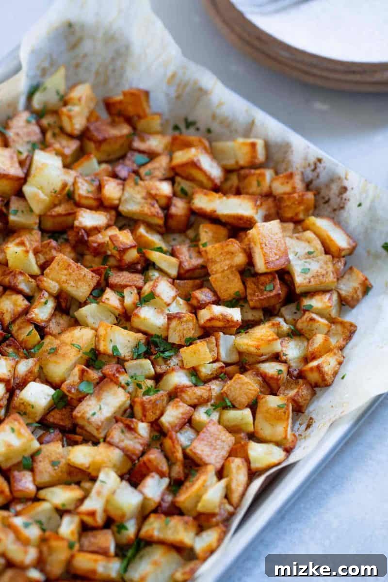 Golden Roasted Five Spice Potatoes 7 A large serving platter piled high with golden roasted five spice potatoes, garnished with fresh herbs, ready to be enjoyed.