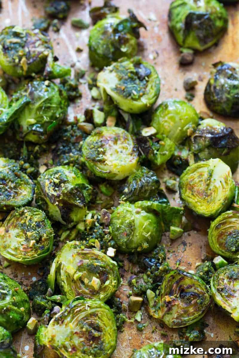 A baking sheet filled with halved brussels sprouts ready for roasting, highlighting the surface area for crisping.