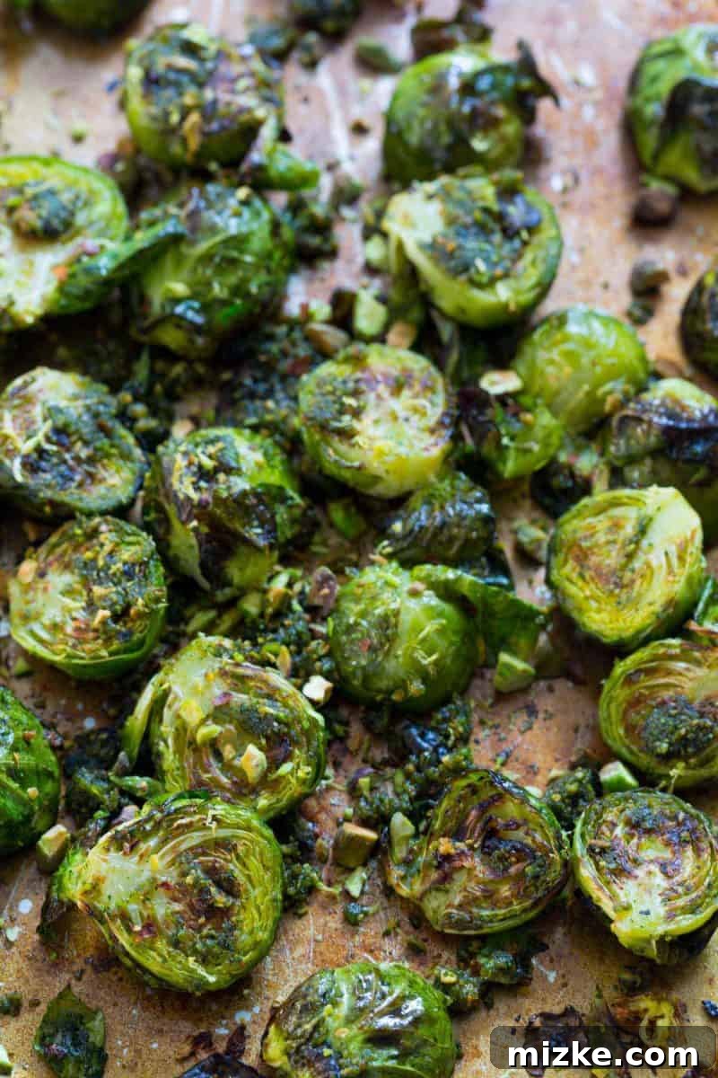 A beautifully arranged serving of pistachio pesto brussels sprouts, garnished with extra chopped pistachios.