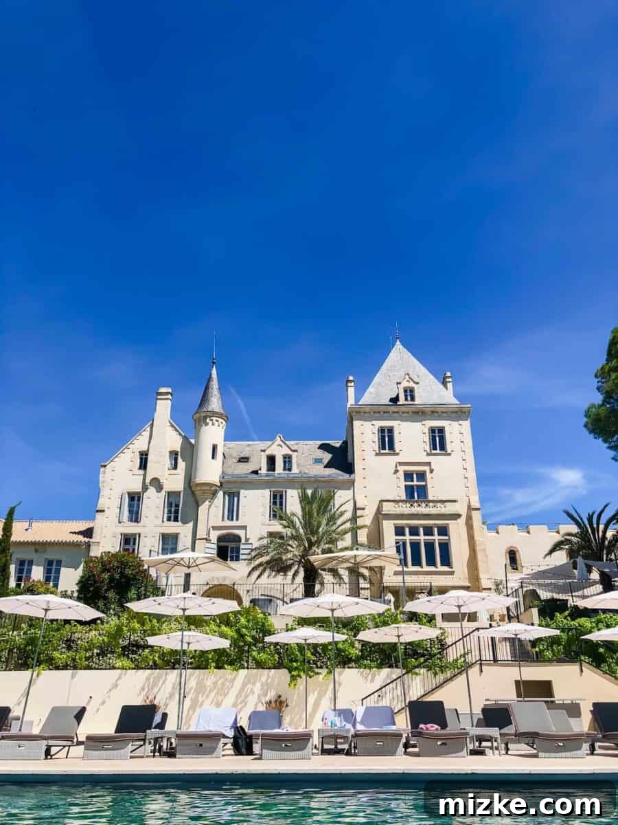Stunning view of a Southern France chateau with sprawling vineyards under a clear sky, embodying luxury group travel and girls getaway dreams.