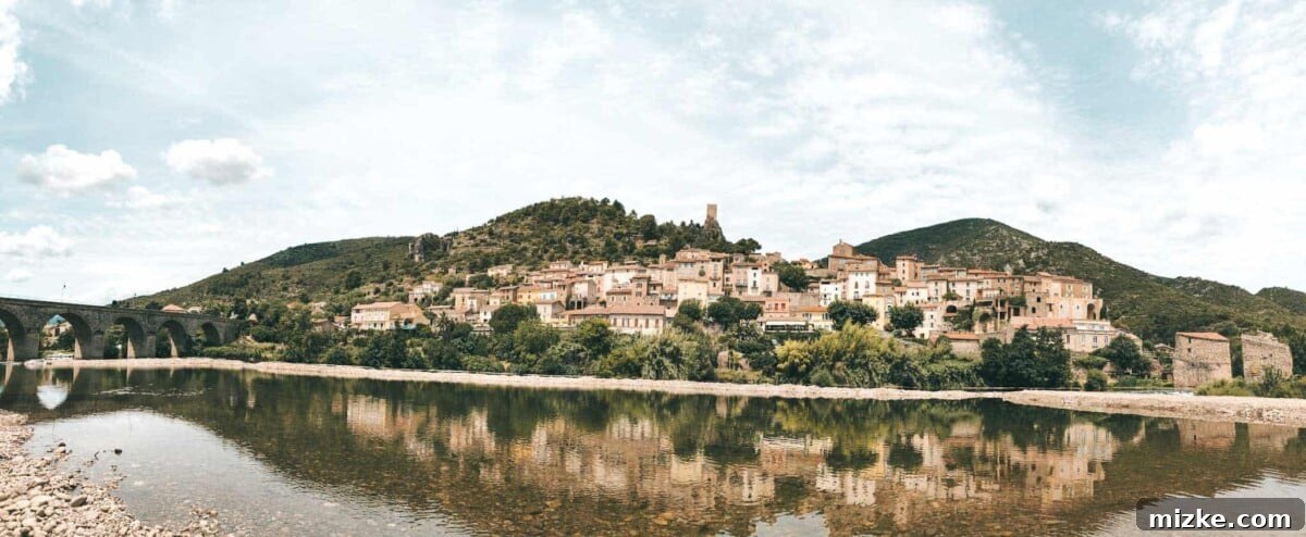 A peaceful river scene in Roquebrun, suitable for water activities like paddle boarding or kayaking.