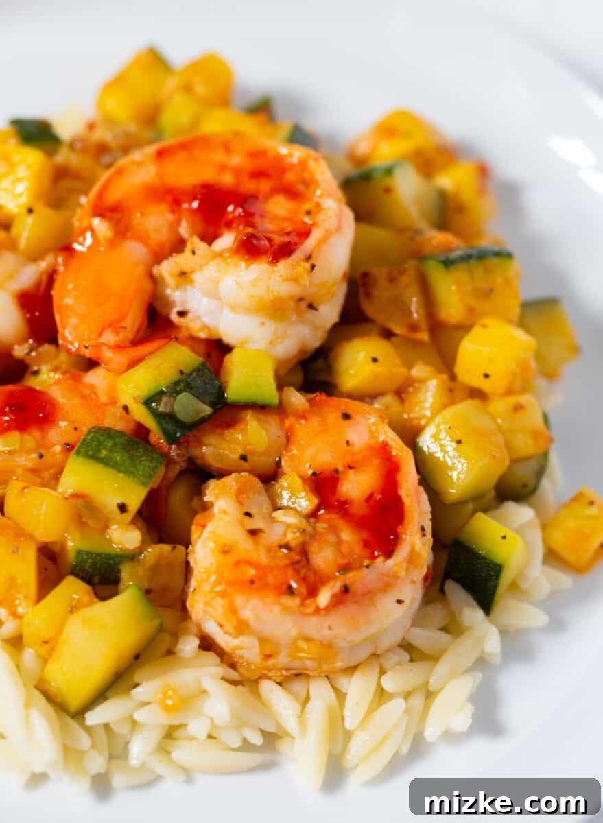 Healthy Shrimp and Zucchini Orzo Dinner A serving of Shrimp and Zucchini Orzo garnished with fresh parsley, highlighting the vibrant colors and appealing texture of this quick and healthy dish.