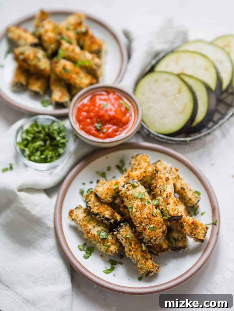 Close-up of golden, textured breading on baked Eggplant Parmesan Fries on a wire cooling rack.