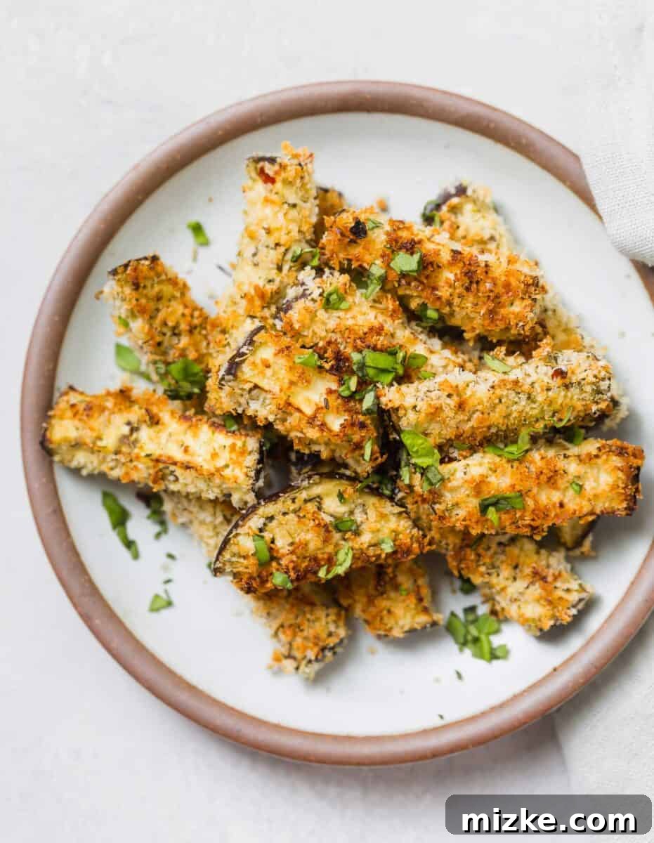 A large serving of freshly prepared Eggplant Parmesan Fries, showcasing their golden-brown breading and appetizing appearance.