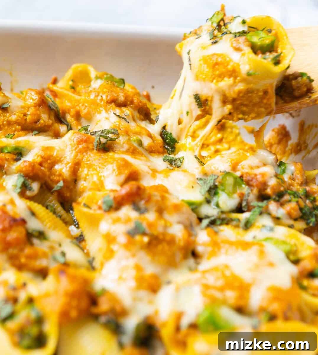 A close-up of hearty stuffed shells brimming with autumn flavors, showcasing the golden-brown cheese topping and vibrant filling.
