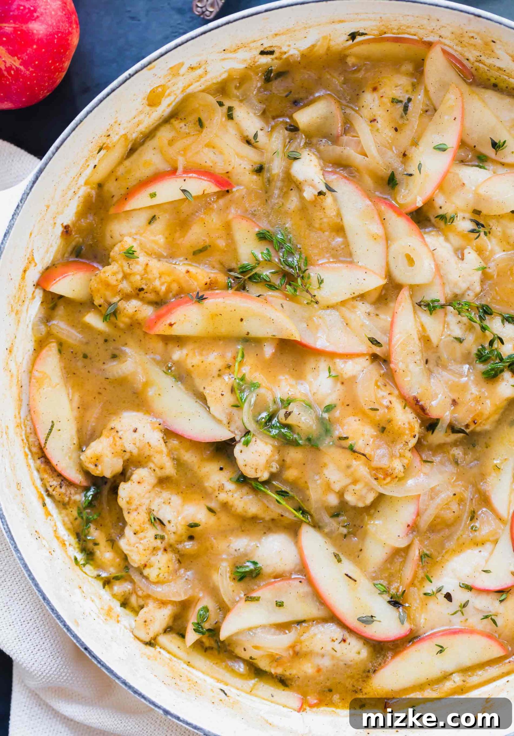Rustic Apple Cider Chicken Skillet 2 Overhead shot of a beautifully cooked apple cider chicken skillet garnished with fresh herbs