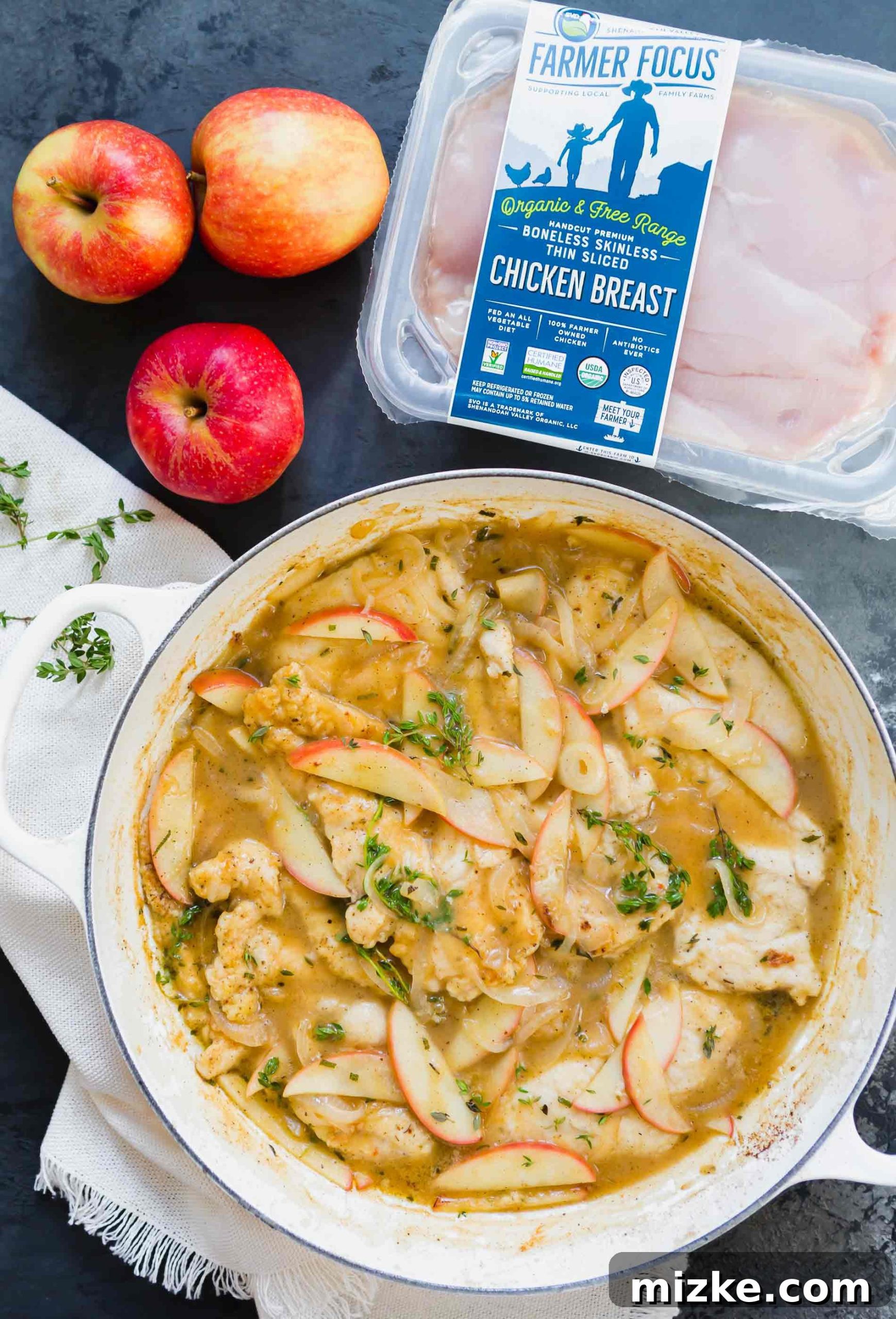 Rustic Apple Cider Chicken Skillet 3 Overhead photo of a cooked apple cider chicken skillet next to a package of Farmer Focus thin-sliced chicken breast