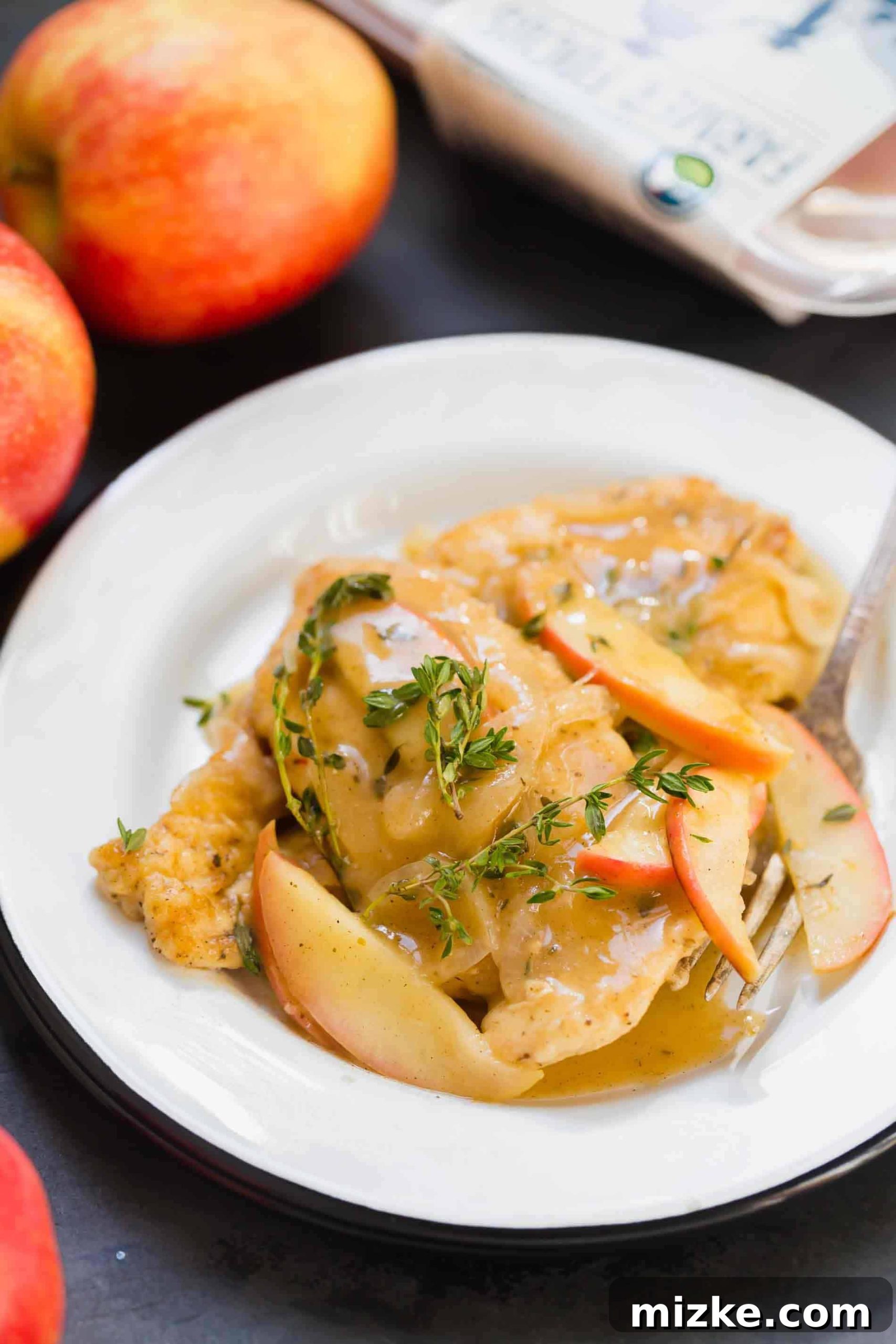 Rustic Apple Cider Chicken Skillet 6 A serving of apple cider chicken skillet beautifully plated on a white plate with fresh parsley garnish