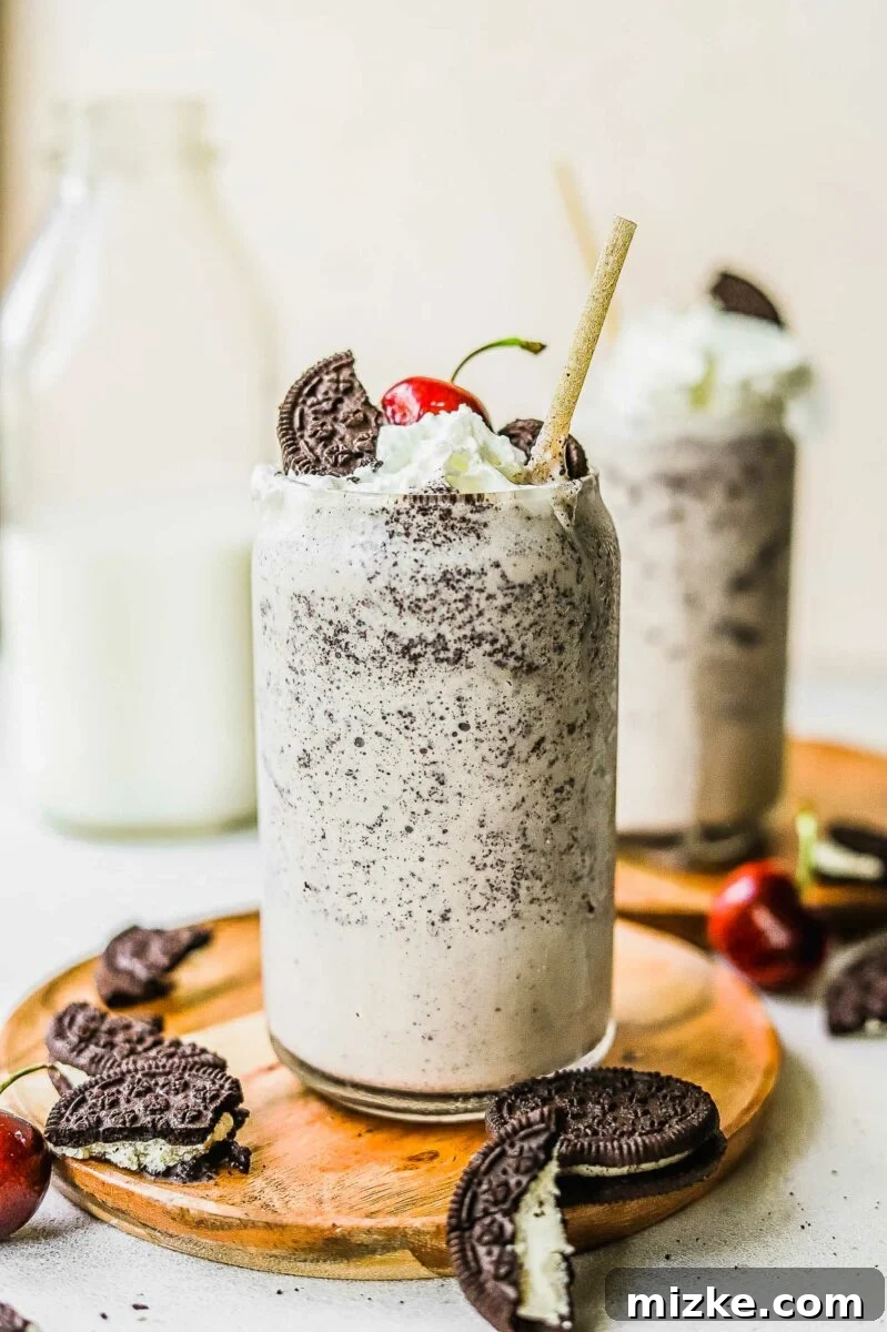 Midnight Cookie Delight 6 A perfectly blended Oreo milkshake, rich and dark, served in a glass on a rustic wooden plate.