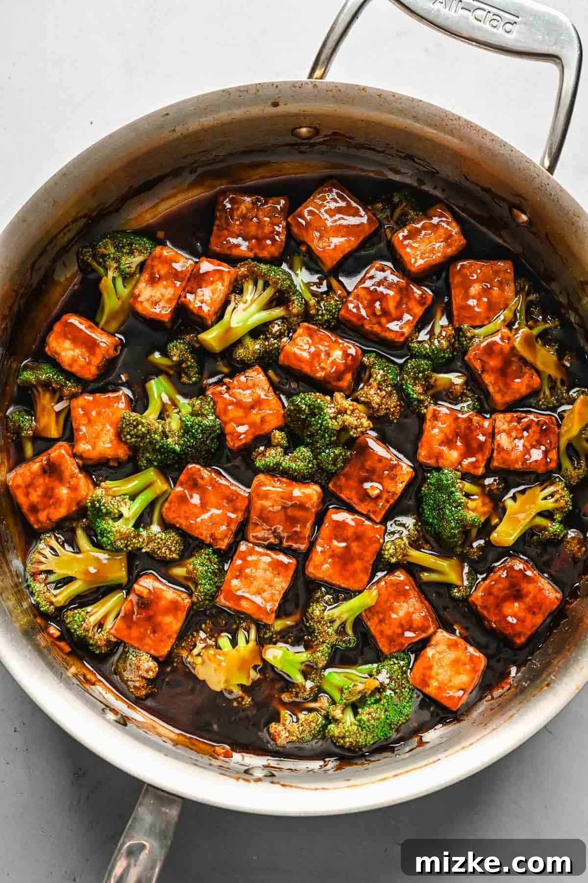 Satisfy your craving for Asian take-out with these teriyaki tofu and broccoli bowls, an easy plant-based dinner for any night of the week! Cubed tofu, broccoli, and teriyaki sauce combined in a skillet.
