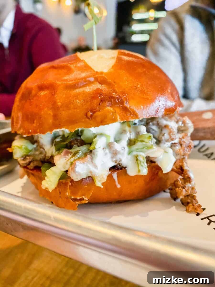 DC Date Night Done Right: Emmy Squared 5 A mouth-watering chopped cheese burger, featuring seasoned ground beef, generously melted cheese, and fresh vegetables on a soft bun.