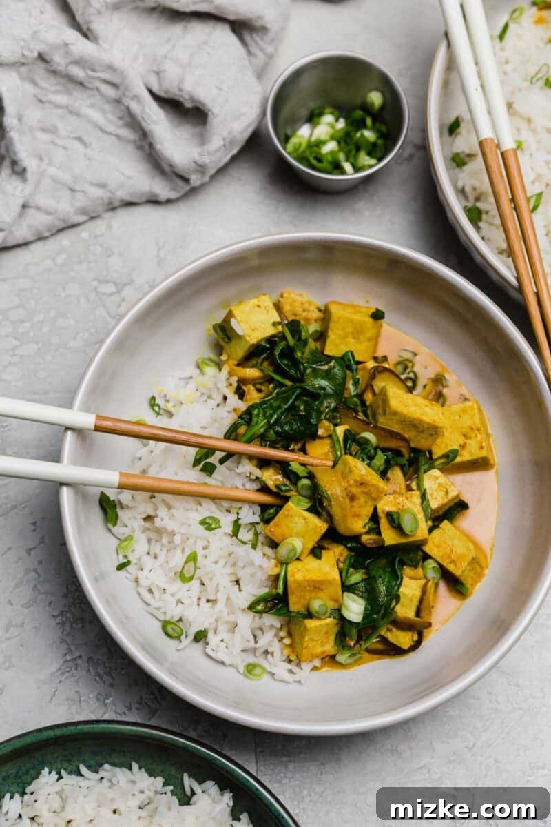 Vibrant Tofu Coconut Curry Bowl with Fresh Spinach This tofu coconut curry bowl is simmered in a deliciously warm coconut curry sauce along with shiitake mushrooms. A plant-based dinner for any evening!