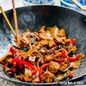 Fiery Basil Noodle Stir-fry 2 Drunken noodles with tofu in wok with chopsticks.