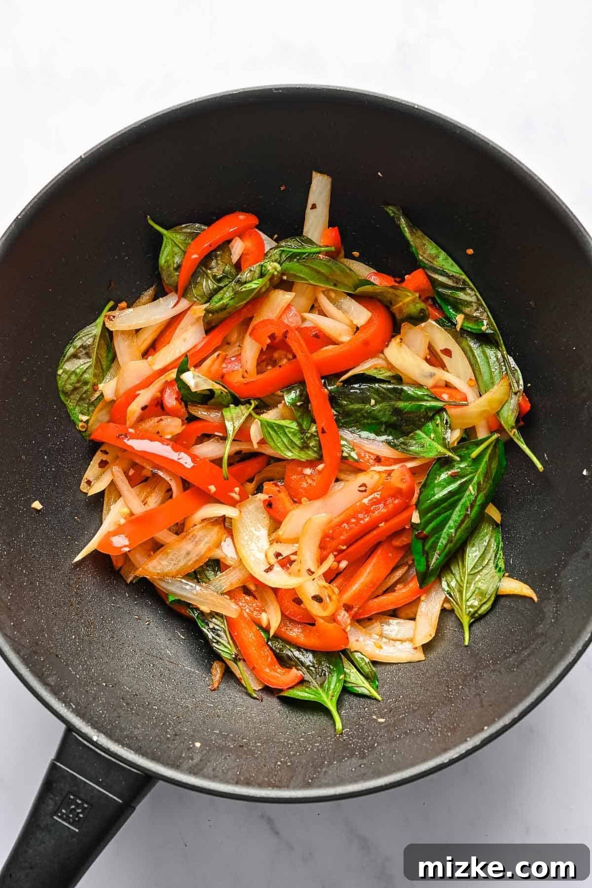 This recipe for drunken noodles with tofu is full of flavor and easy enough for a weeknight. Make your favorite Thai dish right at home! Stir-fried noodles and vegetables in a wok.