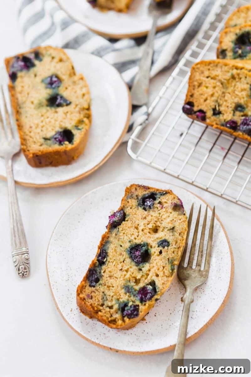 Blueberry Burst Banana Loaf 4 A beautifully sliced piece of blueberry banana bread revealing the soft interior and scattered blueberries.