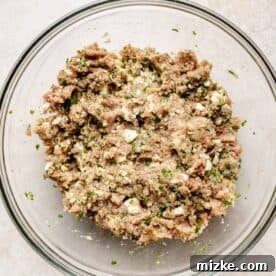 Mediterranean Turkey Spinach Feta Burgers 6 A large clear bowl containing the well-mixed turkey spinach feta burger mixture, showing the vibrant green of the spinach.