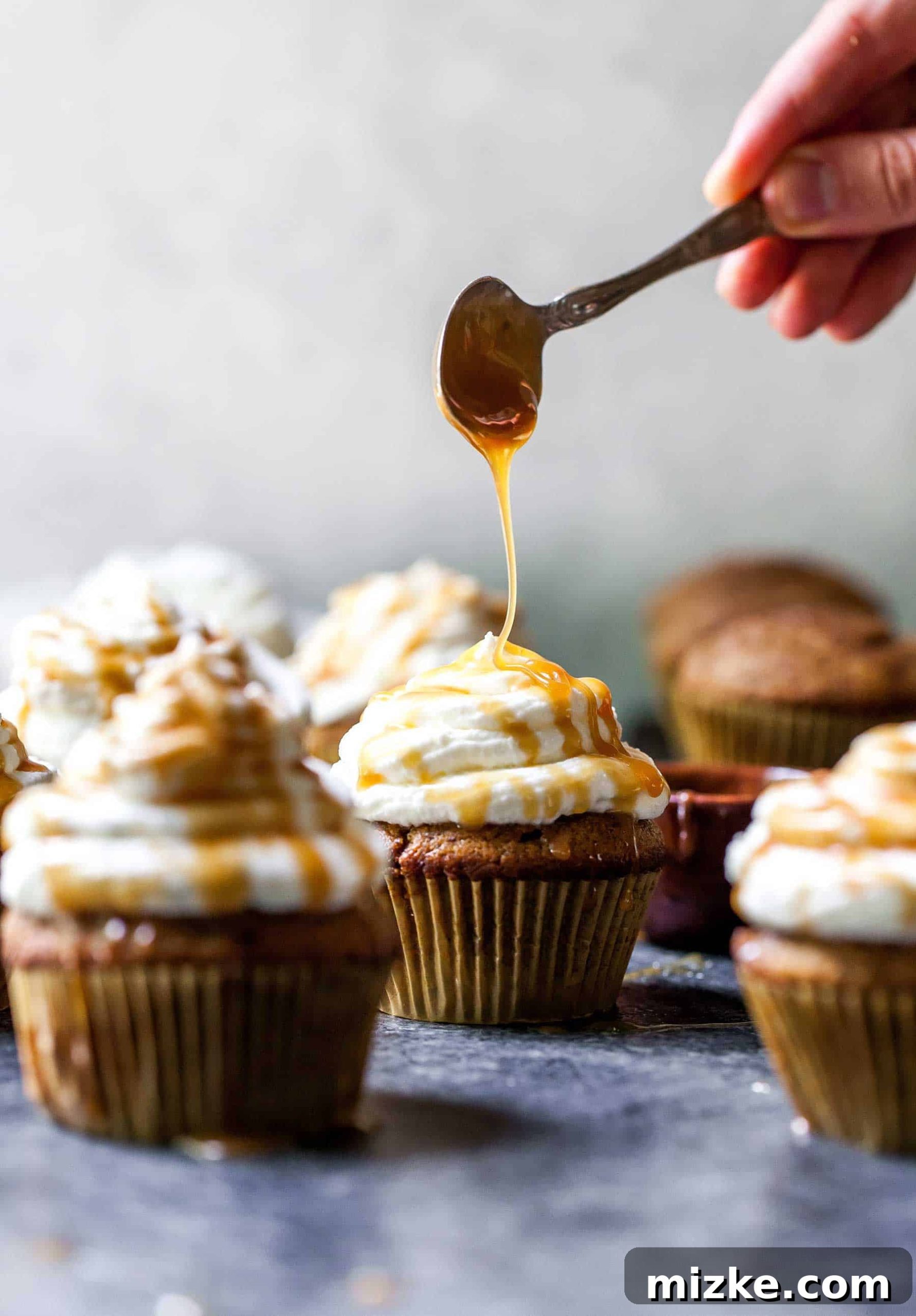 Cozy Pumpkin Spice Latte Cupcakes 2 Caramel sauce being drizzled over the tops of pumpkin spice latte cupcakes, showcasing a delicious autumn treat.