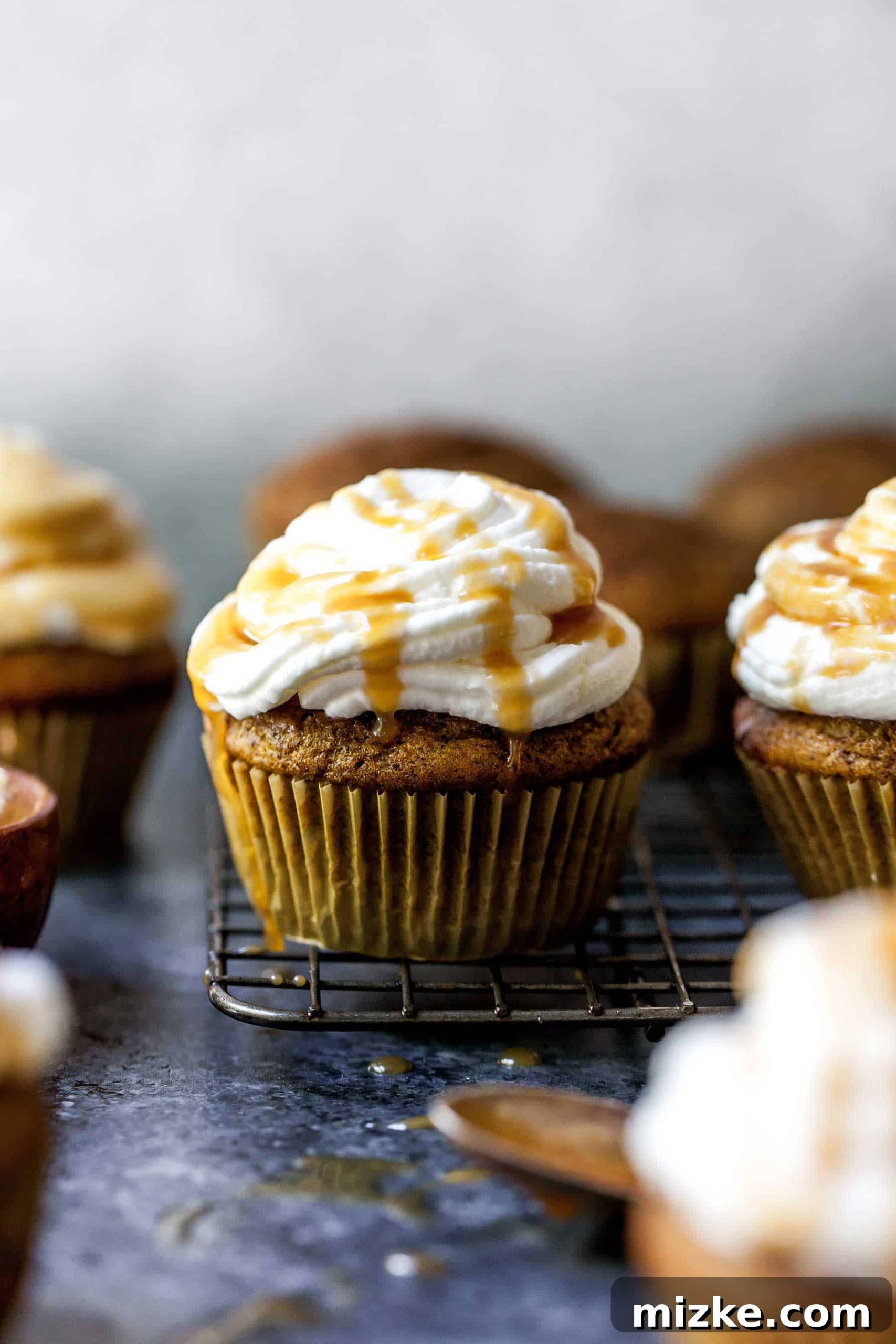 Cozy Pumpkin Spice Latte Cupcakes 4 Closeup shot of a frosted pumpkin spice latte cupcake on a cooling rack, perfectly ready for a fall treat.