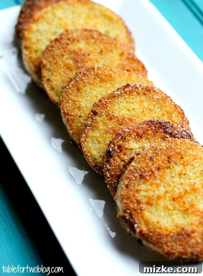 Whispers at Whistle Stop 3 Close-up of a single fried green tomato slice showcasing its golden-brown, crispy crust.