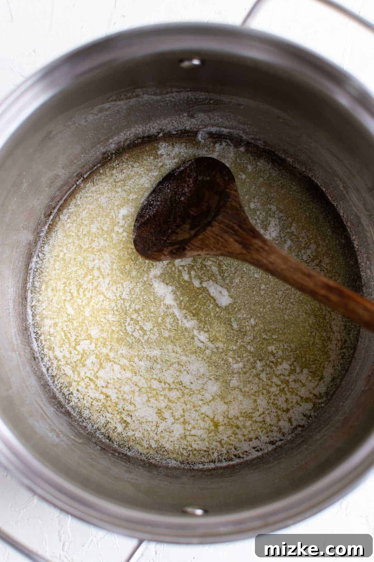 Crunchy Wreath Delights 3 Butter melting gently in a medium pot over a stove, the first step to a delicious marshmallow mixture.