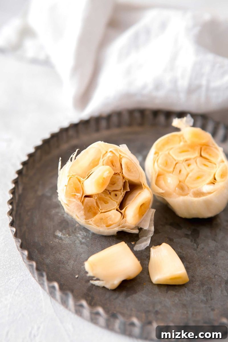 Unlock the Flavor of Roasted Garlic 3 Close-up of a perfectly roasted garlic head, showing soft, golden-brown cloves ready to be gently squeezed out and enjoyed.