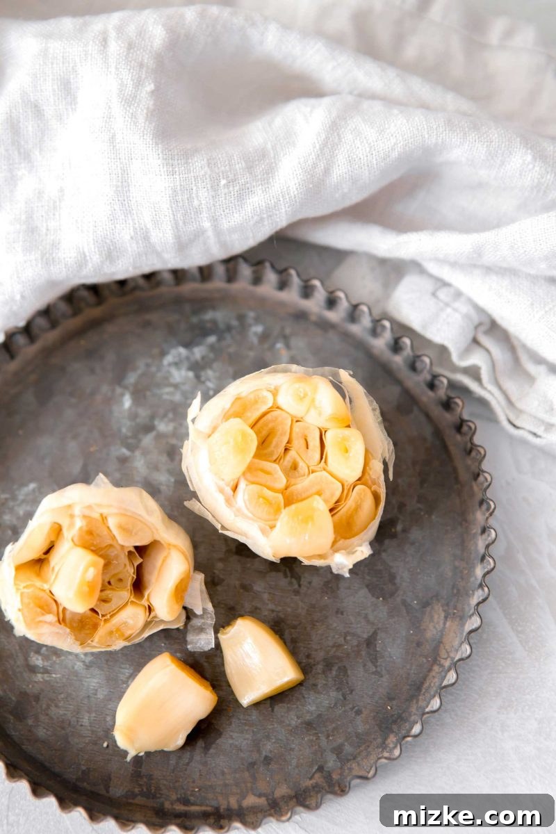Unlock the Flavor of Roasted Garlic 4 A garlic bulb with the top expertly sliced off, revealing the cloves, glistening with olive oil and seasoned with salt, poised for the oven.