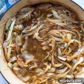 French Onion Smothered Chicken 7 beef broth and fresh thyme has been added to the caramelized onions in the dutch oven
